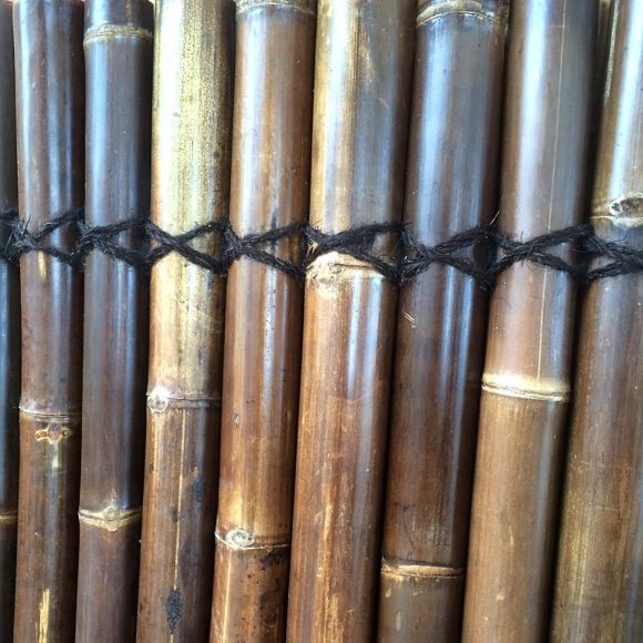 Panneau constitué de demi-cannes de bambou naturel, couleur noir.