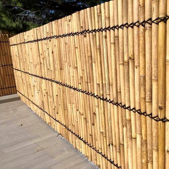 Palisssade ou mur constitué de panneau en bambou naturel, couleur jaune.